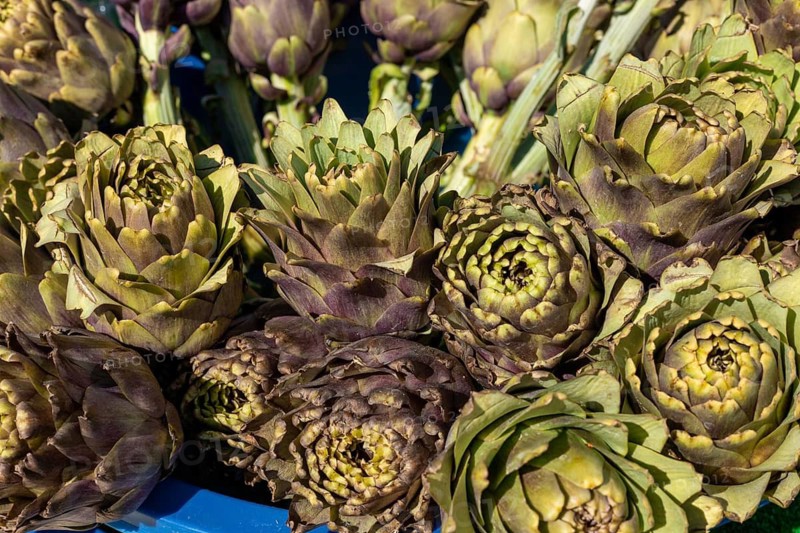 A collection of artichokes with layers of green leaves nestled together