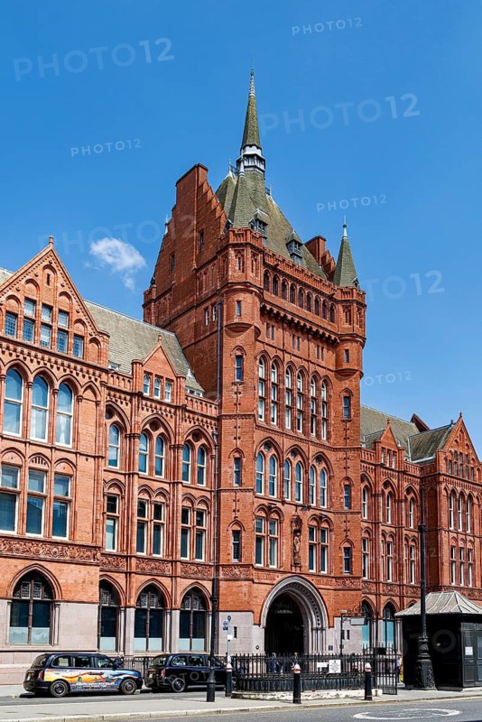 The red terracotta tower and fleche of Holborn Bars rise above High Holborn, part of Alfred Waterhouse's Victorian Gothic headquarters built for the Prudential Assurance Company in phases between 1879 and 1901 and now a Grade II listed office building. London, England, United Kingdom