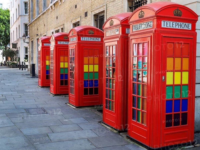 Five red K2 telephone kiosks designed by Giles Gilbert Scott in 1927 stand in a row at Broad Court, their windows fitted with colourful stained glass. Among London's finest surviving groups of cast iron kiosks, they were listed Grade II in 1986. London, England, United Kingdom