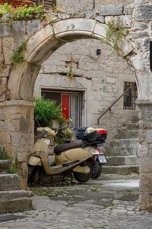 E-fun Pusa electric scooters in an arched entryway, Trogir, Croatia