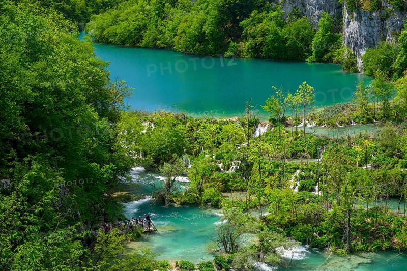 A high view of tourists viewing the waterfalls at Plitvice Lakes National Park, Croatia