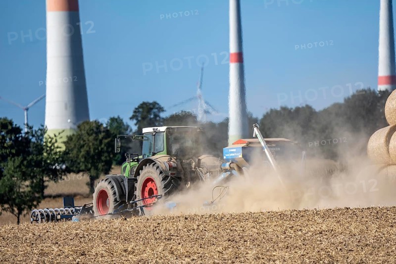 Tractor cultivates a harvested grain field, loosens the soil and then places seeds directly, with a pneumatic seeder, dry soil, heavy dust development, near Paderborn-Dahl, North Rhine-Westphalia, Germany