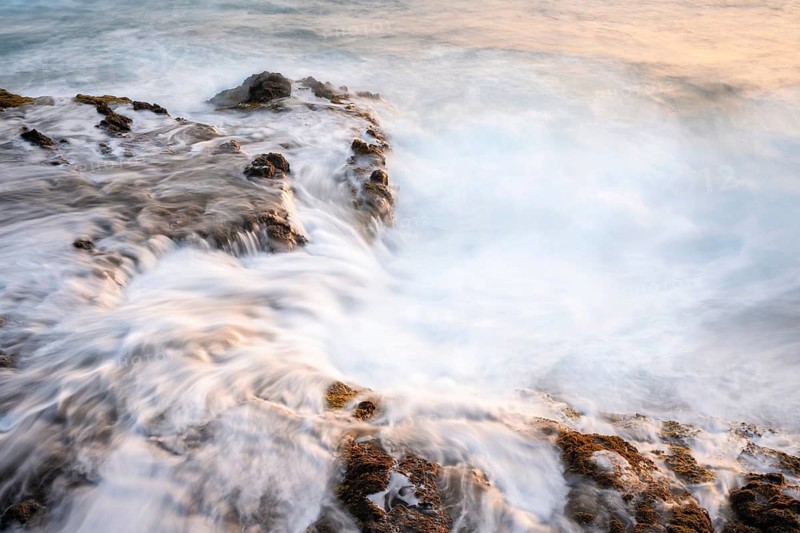 Seawater flows over lava rocks. Long exposure, morning light. Coast near Puerto de Talavera, La Palma, Canary Islands, Spain