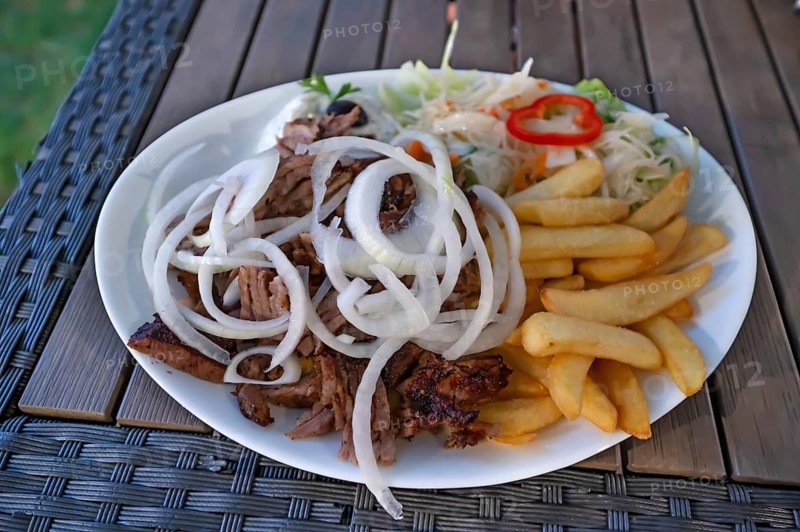 Giros served with French fries and raw onion rings in a Greek garden restaurant, Franconia, Bavaria, Germany