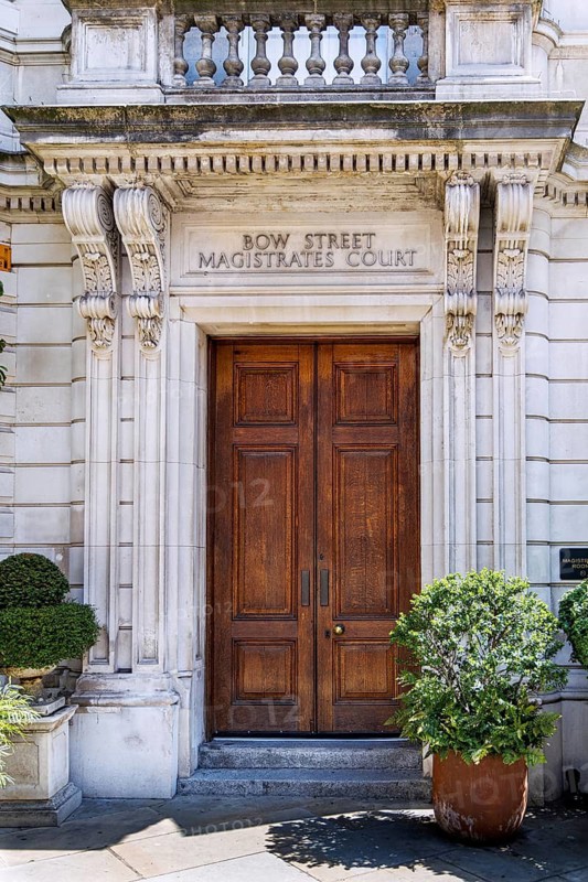The carved stone doorway and pediment mark the former Bow Street Magistrates' Court, which originated in 1740 when Sir Thomas de Veil sat as magistrate. Henry Fielding later founded the Bow Street Runners here in the same building's lineage. London, England, United Kingdom