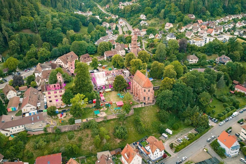 Village with festival, church and residential buildings surrounded by green nature, Calwer Klostersommer Festival, Hirsau Abbey, Calw, Black Forest, Germany