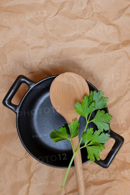 Parsley and cooking spoon on pot