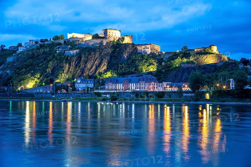 The Ehrenbreitstein Fortress, on the right side of the Rhine, opposite the Deutsches Eck, evening lighting, sightseeing boat on the left bank, Koblenz, Rhineland-Palatinate, Germany