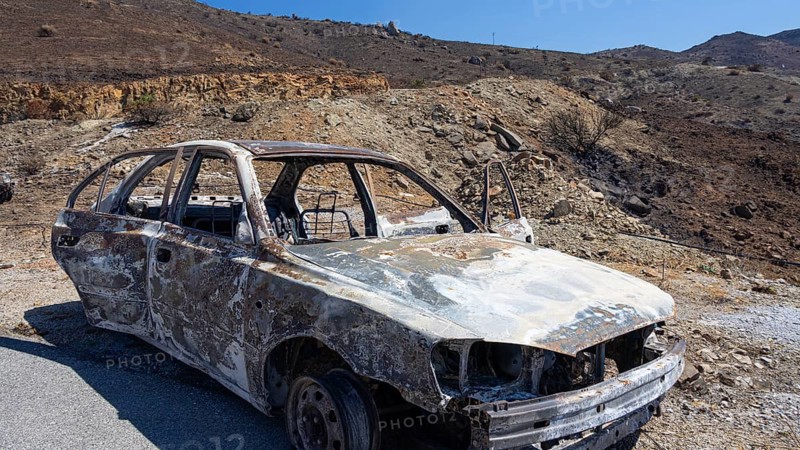A rusty, burnt vehicle in a mountainous, barren environment, forest fire, fire damage, fire on July 29 and 30, 2026, Agios Pavlos, bay on the south coast, south coast, Retimnon province, Crete, Greek Islands, Greece