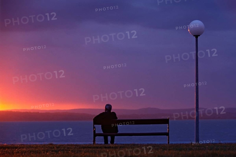 Europe, Greece, Crete, man sitting on bench looking at the sea, sunset, Men sit on a bank and take o look to the water, Greece