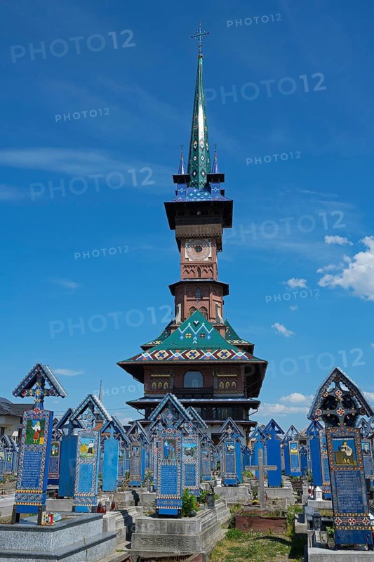 Historic church tower overlooks ornate tombs under a clear sky, traditional wooden grave sites, Merry Cemetery, Cimitirul Vesel, Sapân?a, Sapanta, Maramures, Maramures, Maramures, Romania