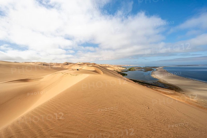 Sand dunes and sea, Atlantic coast and sandy desert with sea of dunes, view of lagoon at Sandwich Harbour, Namib Naukluft Park, Namib Desert, Namibia