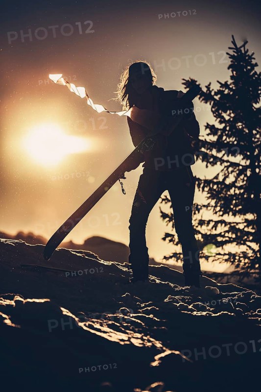 A woman's ski tour at sunrise on the Tegelberg in the Allgäu in the Ammergebirge, Bavaria, Germany