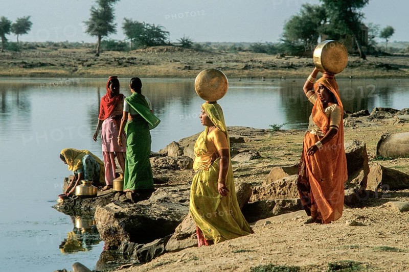 Women carry stuffed water balls on their heads at Gadsisar Lake, Jaisalmer, Rajastan, India
