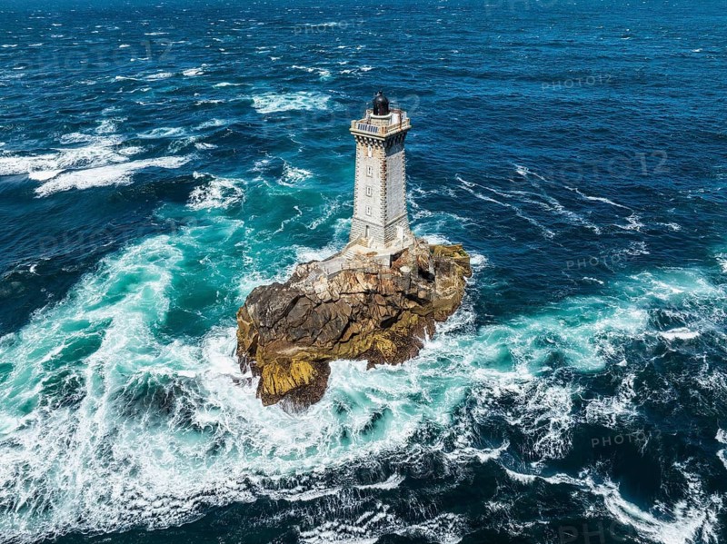 Aerial view of the historic Phare de la Vieille lighthouse, built from 1882 to 1887 on a rocky reef in the midst of stormy, foaming ocean waves, Raz de Sein strait, Pointe du Raz, Plogoff, Quimper Arrondissement, Finistère, Région Bretagne, France