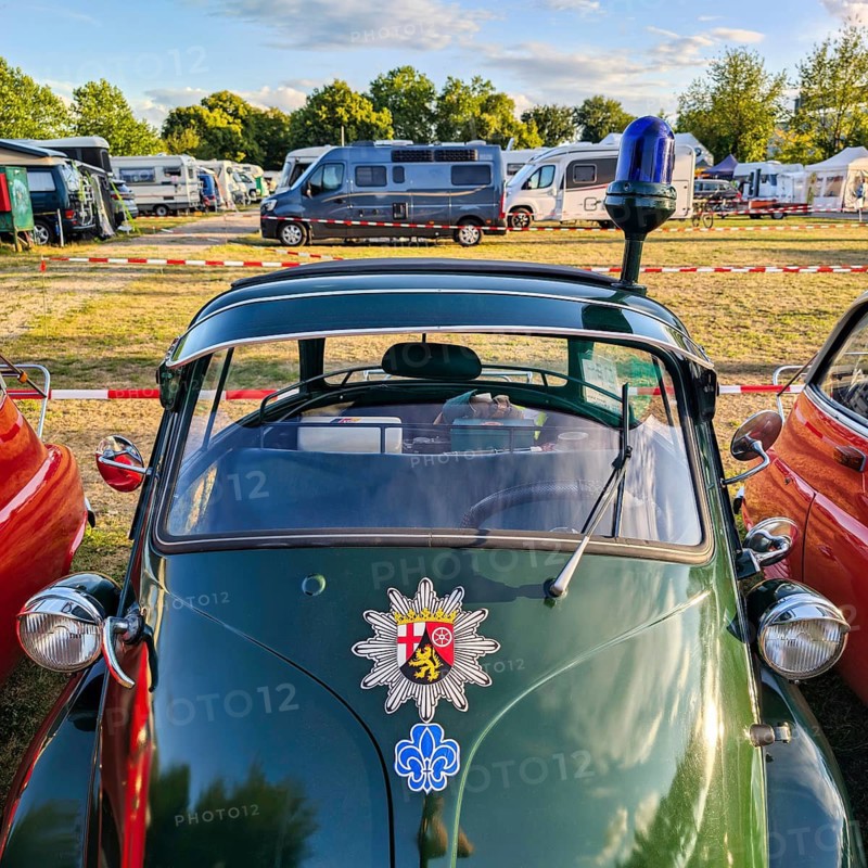 BMW Isetta, annual meeting 2026, distinctive dark green small car with front door, patrol car with flashing lights and police star, cult, nostalgia, smooch ball, historic cultural property, Holzminden campsite, Weser Hills, Germany