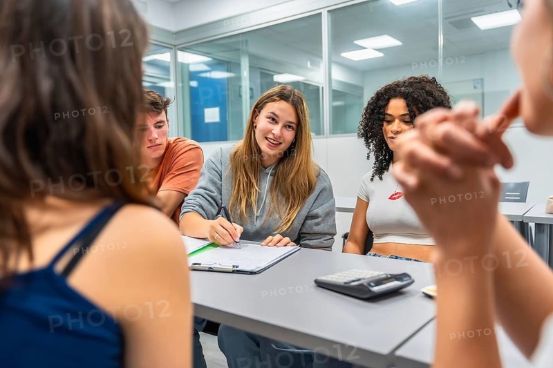 Young diverse students collaborating, learning, and actively participating in a modern classroom setting during a university or college lecture, representing teamwork and education