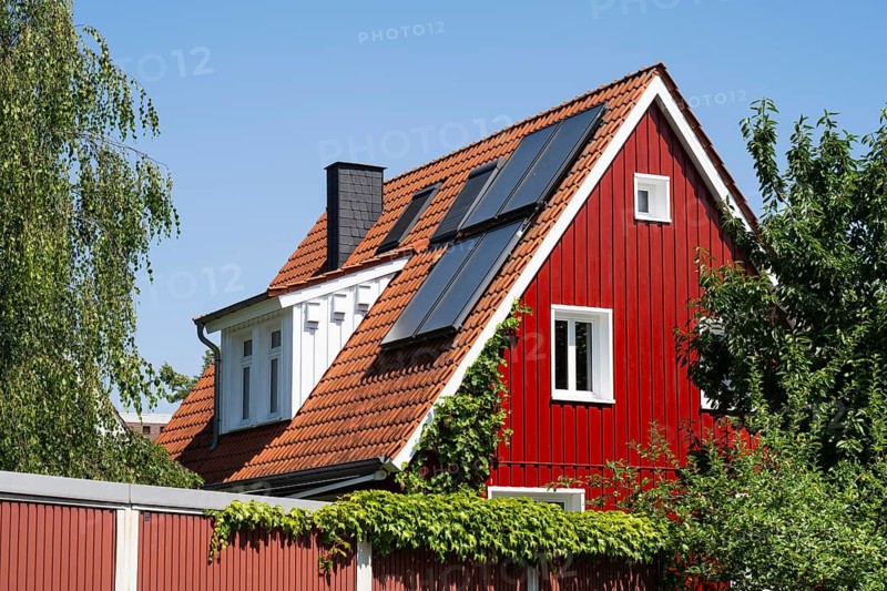 House with pointed gable, photovoltaic on the roof, red wooden façade, sky, Westphalia, North Rhine-Westphalia, Germany