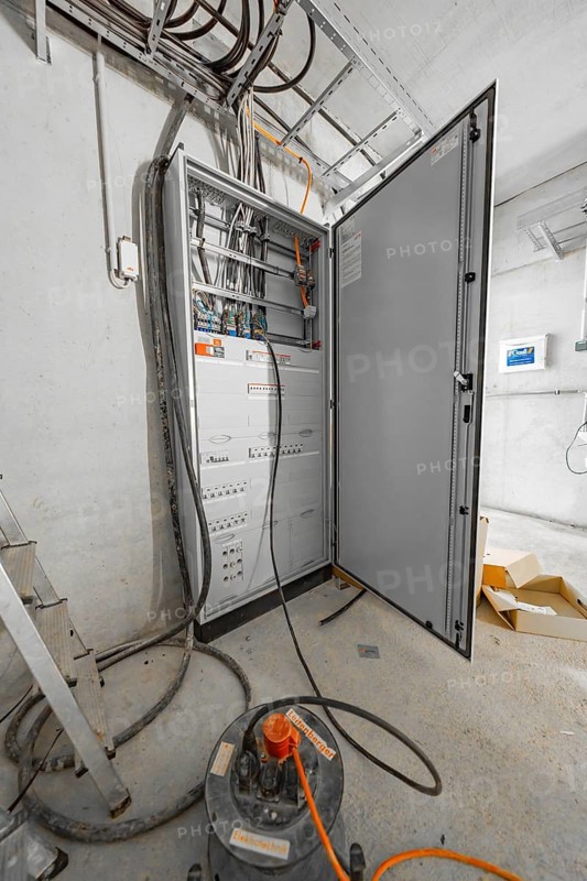 An open electrical cabinet shows cables and sockets in a technical room, Parkhausbau, Calw, Germany