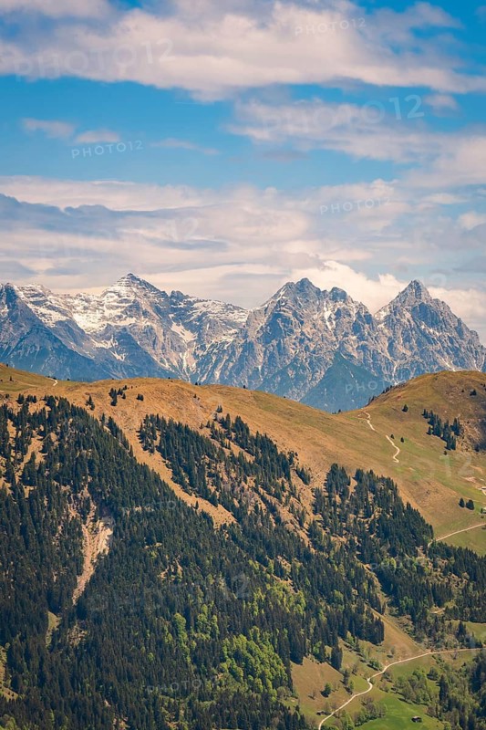 Panoramic view of snow-capped mountains and wooded hills with a trail, Hahnenkamm, Kitzbühel, Austria