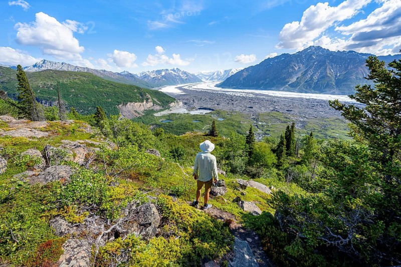 Young man enjoying the view, view of impressive mountain landscape with Matanuska glacier and glaciated mountain peaks, Lion's Head, Chugach Mountains, Alaska, USA