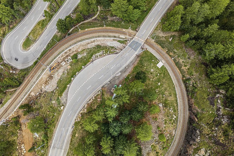 Red train of the Rhaetian railroad line, Bernina Express, 180 degree turn at the Montebello curve, aerial view, Morteratsch, Switzerland