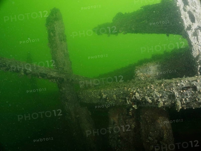 Weathered wooden structures of a wreck in deep green water with a mysterious atmosphere, wreck Margareta af Vätö dive site, Konabbsfjärden, Nynäshamn, Stockholm, Sweden