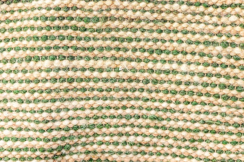 A close-up view of a woven fabric with alternating green and beige stripes. The texture is soft and natural, suitable for various textile applications