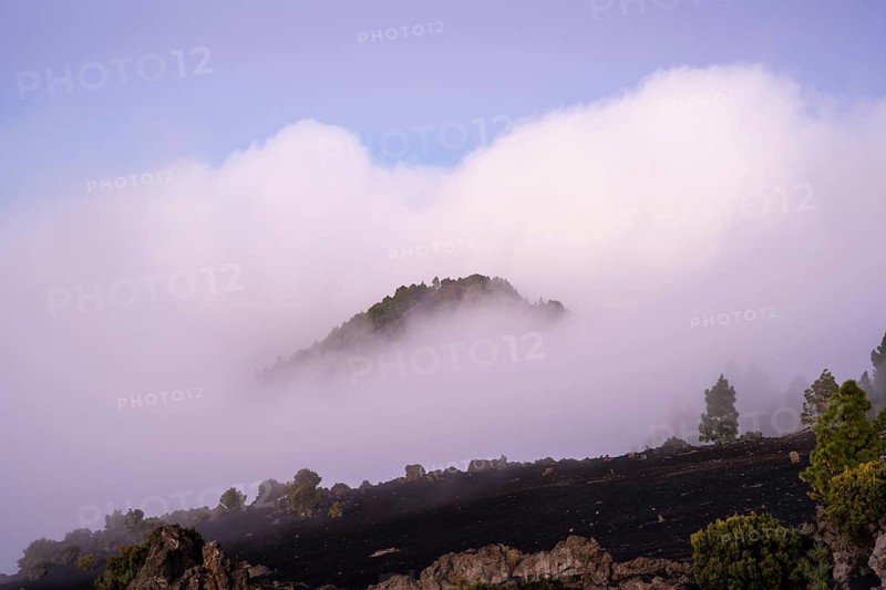 View from Mirador Astronómico del Llano del Jable of evening clouds moving across a hill at sunset. La Palma, Canary Islands, Spain