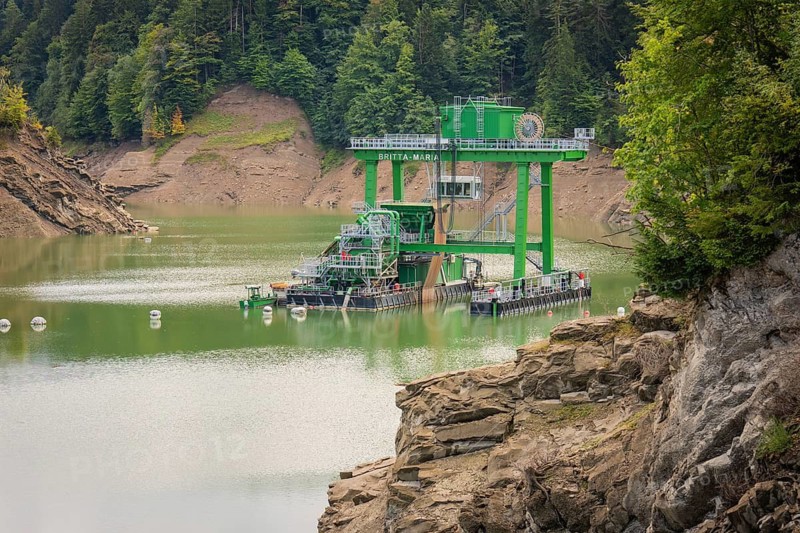 Technical structure on a reservoir surrounded by rocks and wooded hills, Krumbach, Vorarlberg, Austria