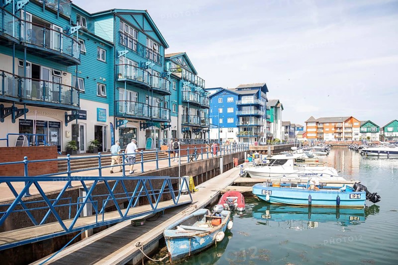 Boats at moorings, modern residential housing development at Exmouth Quay marina, Exmouth, Devon, England, UK