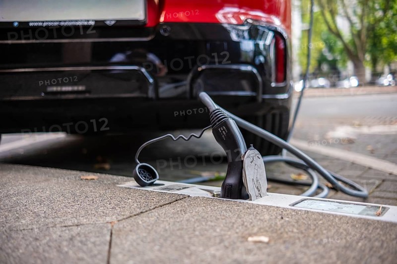 An e-car is charged with a cable at a charging curb on the KÖ, Düsseldorf, Germany