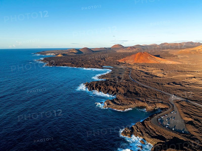 Coast with lava fields, volcanic landscape near Los Hervideros with red volcano Montaña Bermeja, in the evening light, aerial view, Lanzarote, Canary Islands, Spain