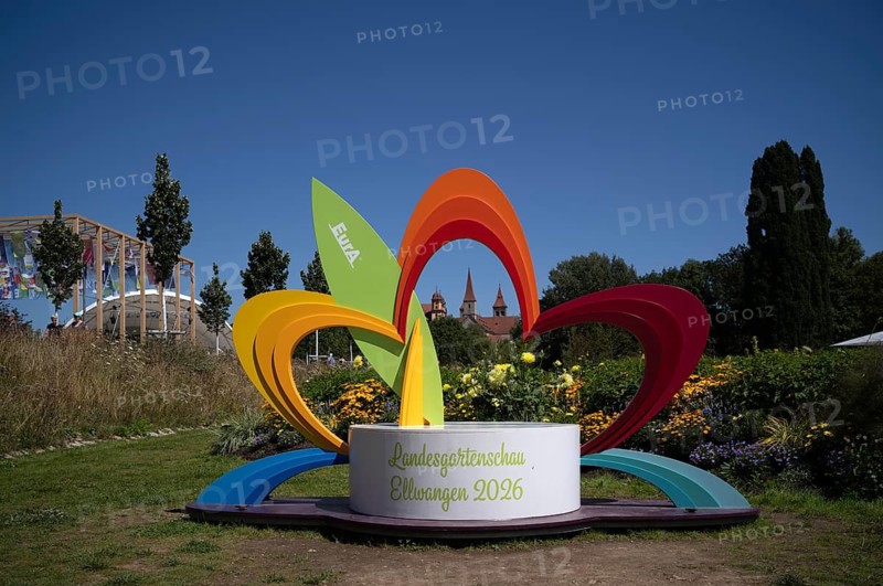 EurA AG logo on a symbol, a sculpture of a flower, with the Protestant Town Church and the monastery's collegiate church – now St Vitus' Basilica – in the background, State Garden Show 2026, Ellwangen (Jagst), Baden-Württemberg, Germany
