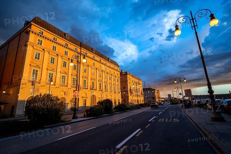 Magnificent buildings on the Riva del Mandracchio seaside promenade in the evening light at sunset, Palazzo della Luogotenenza Austriaca or Palazzo Governo, Greek Orthodox Church of San Nicolò, dramatic clouds, Trieste, Friuli-Venezia Giulia region, Italy