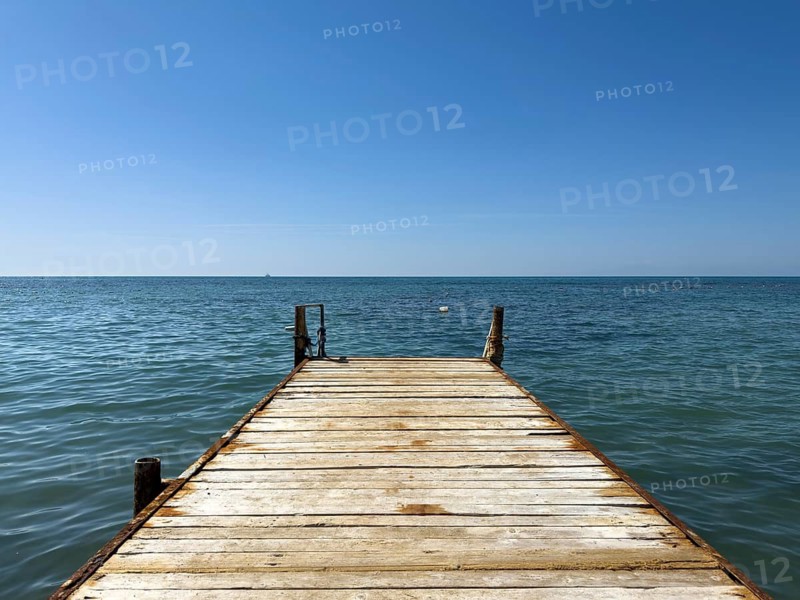 A wooden walkway leads into the calm sea under bright blue sky, Side, Manavgat, Antalya Province, Turkey