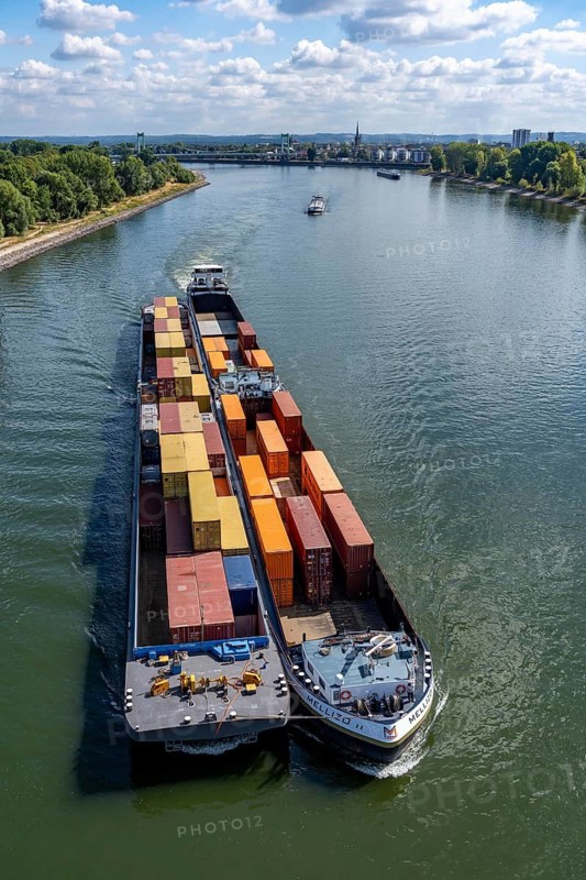 Low water in the Rhine near Cologne, looking north, Mülheimer Rheinbrücke, container freighter Melizzo, in the paddock, push association, due to the distribution over 3 parts of the ship, the draft is not as large and a larger quantity of freight, containers, can be transported at the same time, inland shipping is severely restricted, only a few ships sail, then with a significantly reduced load, on the day of recording it was the lowest ever measured Rhine level in Cologne, 60 cm, Colonia House, high-rise residential building in Cologne-Riehl, 147 meters high, North Rhine-Westphalia, germany