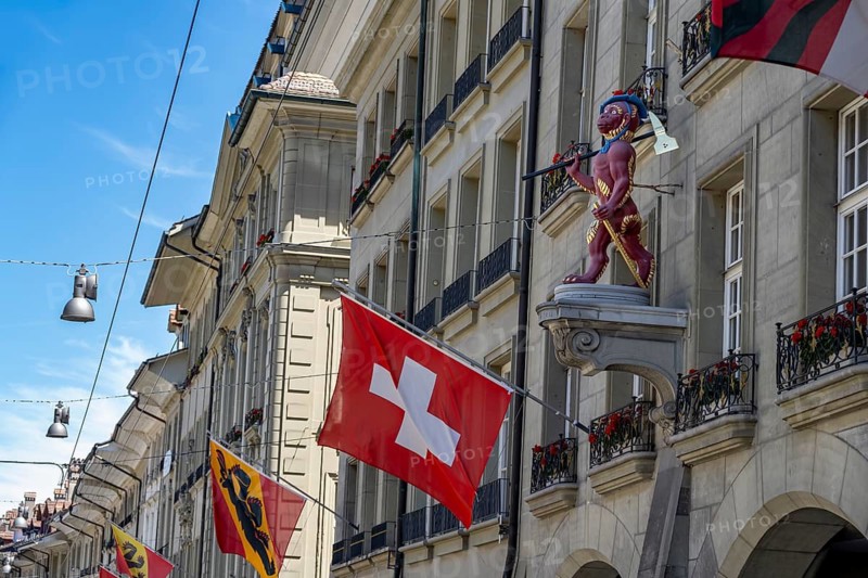 House sign at the guild house of the guild society to the monkey, monkey figure with Swiss national flag on a house façade in the city center, Kramgasse, Bern, Canton of Bern, Switzerland