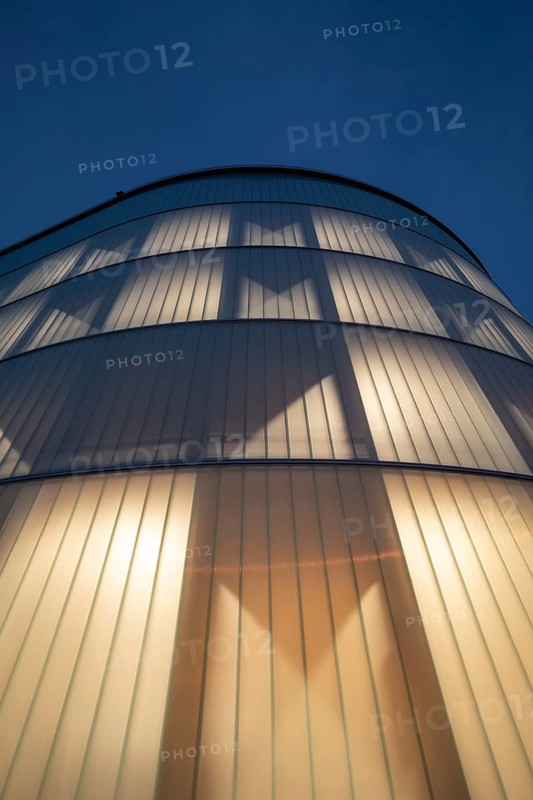 03.05.2026: Illuminated modern timber parking garage (Parkhaus am Bahnhof) with a curved wooden facade at dusk. Wendlingen am Neckar, Baden-Württemberg, Germany