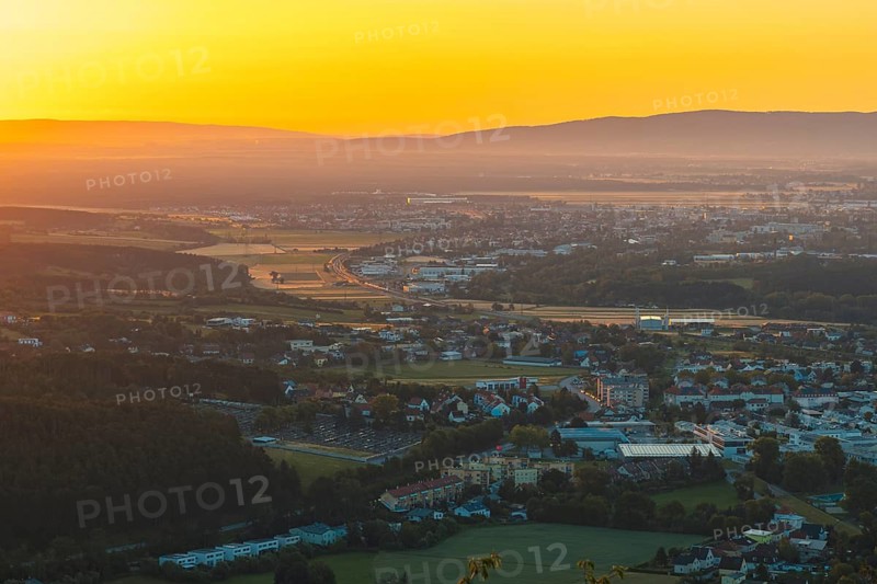 City at sunrise with orange light and surrounding mountains, Ternitz, Lower Austria, Austria