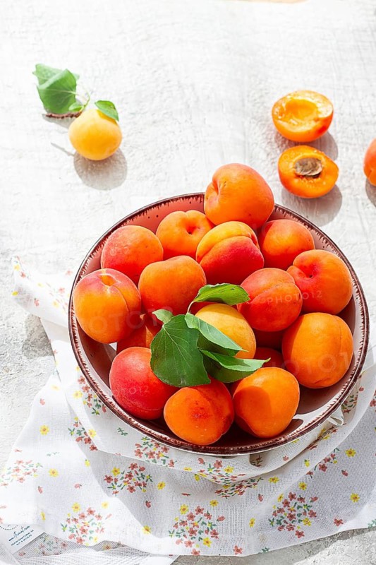 Fresh apricots in a bowl, on a bright table, natural light, top view, no people