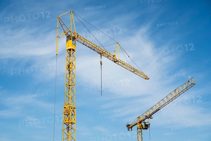 Construction cranes against blue sky with white clouds, Soest, Westphalia, North Rhine-Westphalia, Germany