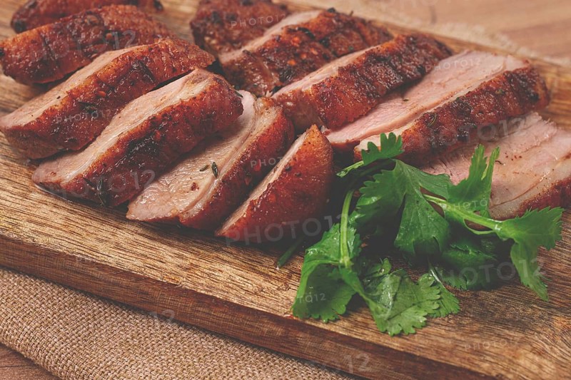 Roast duck breast, sliced, on a wooden chopping board, close-up, no people