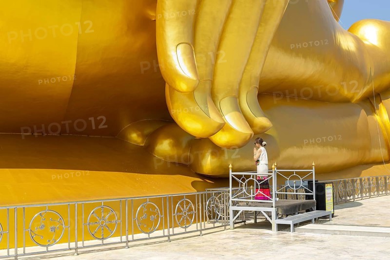 Thailand's largest Buddha statue (Luang Pho Yai), Thai woman, Wai gesture (traditional gesture of respect, greeting or thanks), Wat Muang, Ang Thong, Amphoe Wiset Chai Chan province, Thailand