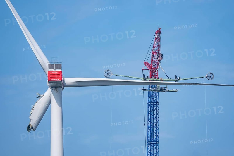 Dismantling a defective wind turbine, dismantling the two intact wings with a large crane, bent blade, in the Bedburg A44n wind farm, in the Garzweiler open-cast mining area, on the A44 motorway, on recultivated lignite mining area, for unknown reasons is a rotor of a Nordex N149/5.7 wind turbine, with a hub height of 164 meters and a total height of 239 meters, an output of 5.7 MW and a rotor diameter of 149 m, bent, the wind turbine is part of a wind farm of a joint venture between the City of Bedburg and RWE Renewables Europe & Australia, North Rhine-Westphalia, Germany