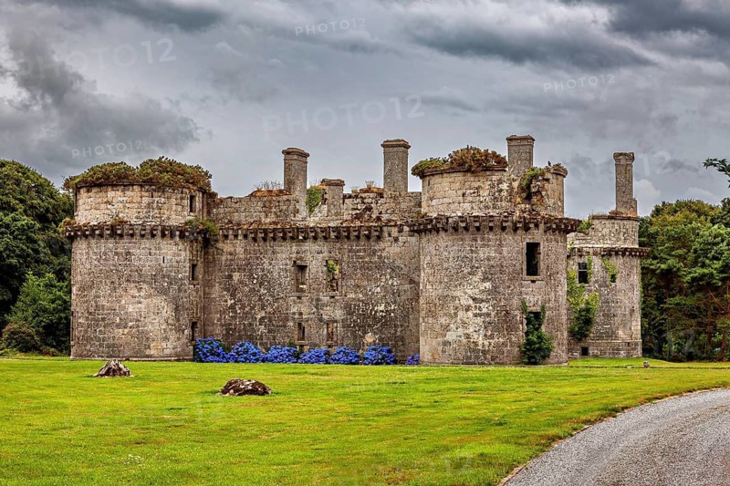 Old stone castle ruins with round towers against a cloudy sky surrounded by nature, The ruins of the Château de Kergournadeac'h in Cléder Brittany