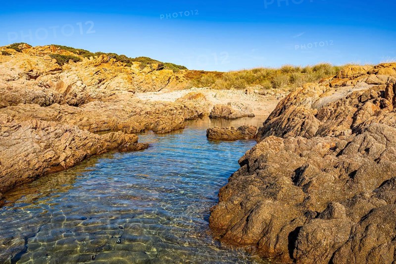 Landscape of the coastline with blue water at Marinedda Coast on a sunny day, Sardinia, Italy