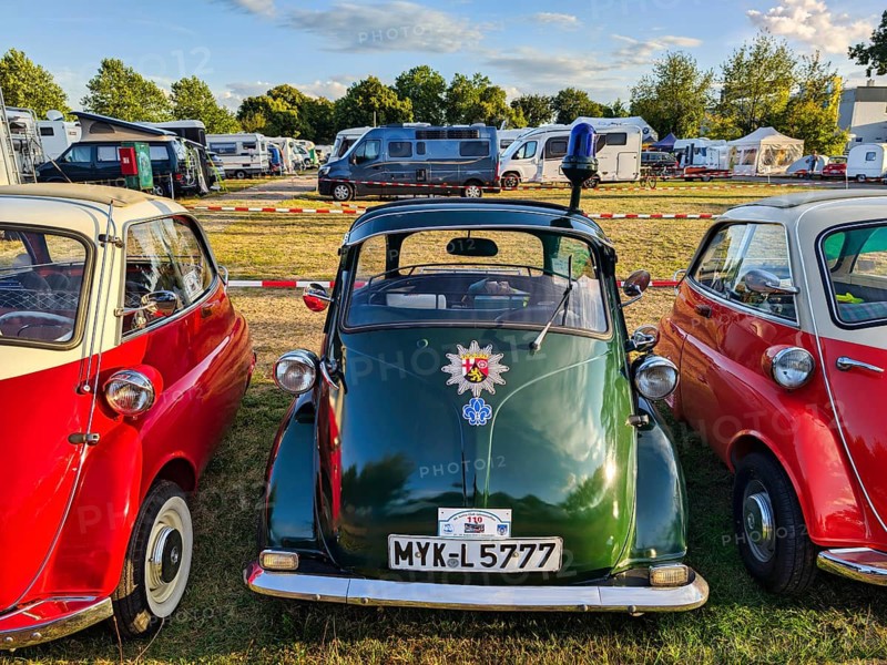BMW Isetta parking in a row, annual meeting 2026, distinctive dark green small car with front door, patrol car with flashing lights and police star, cult, nostalgia, smooch ball, historic cultural property, Holzminden campsite, Weser Hills, Germany