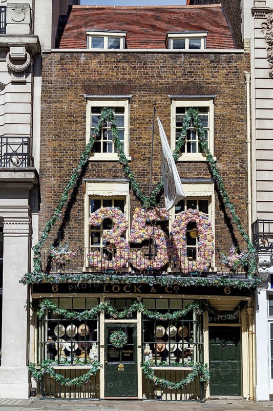A giant floral 350 marks Lock and Co Hatters' anniversary above its shopfront on St James's Street, London, England, United Kingdom