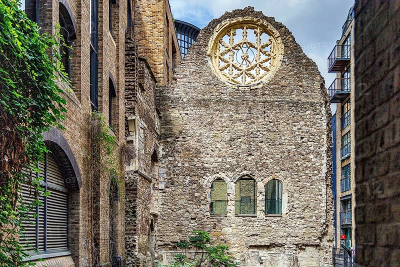 The surviving rose window and stone wall of Winchester Palace, once the London residence of the powerful Bishops of Winchester from the twelfth century, stand hemmed between modern apartment blocks in a quiet Southwark alley near Clink Street, London, England, United Kingdom